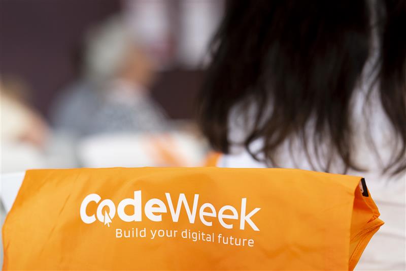 Photo of a cheerful bag branded with the EU Code Week logo and tagline "Build your digital future"